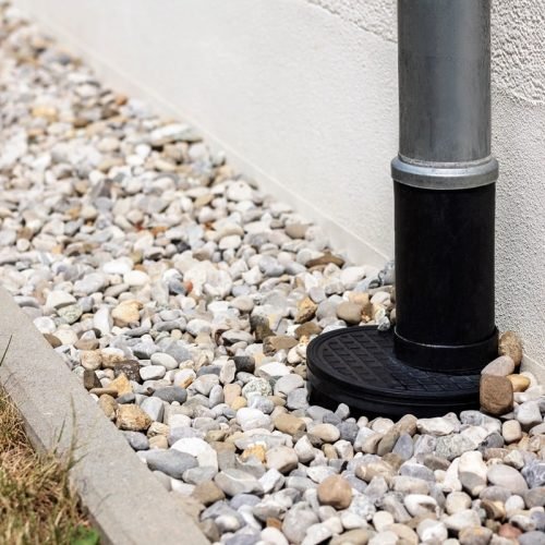 French Drain Building Wall. Drain Pipe going into Drainage  Floor with Gravel Stones aroud House. Drainage Foundation